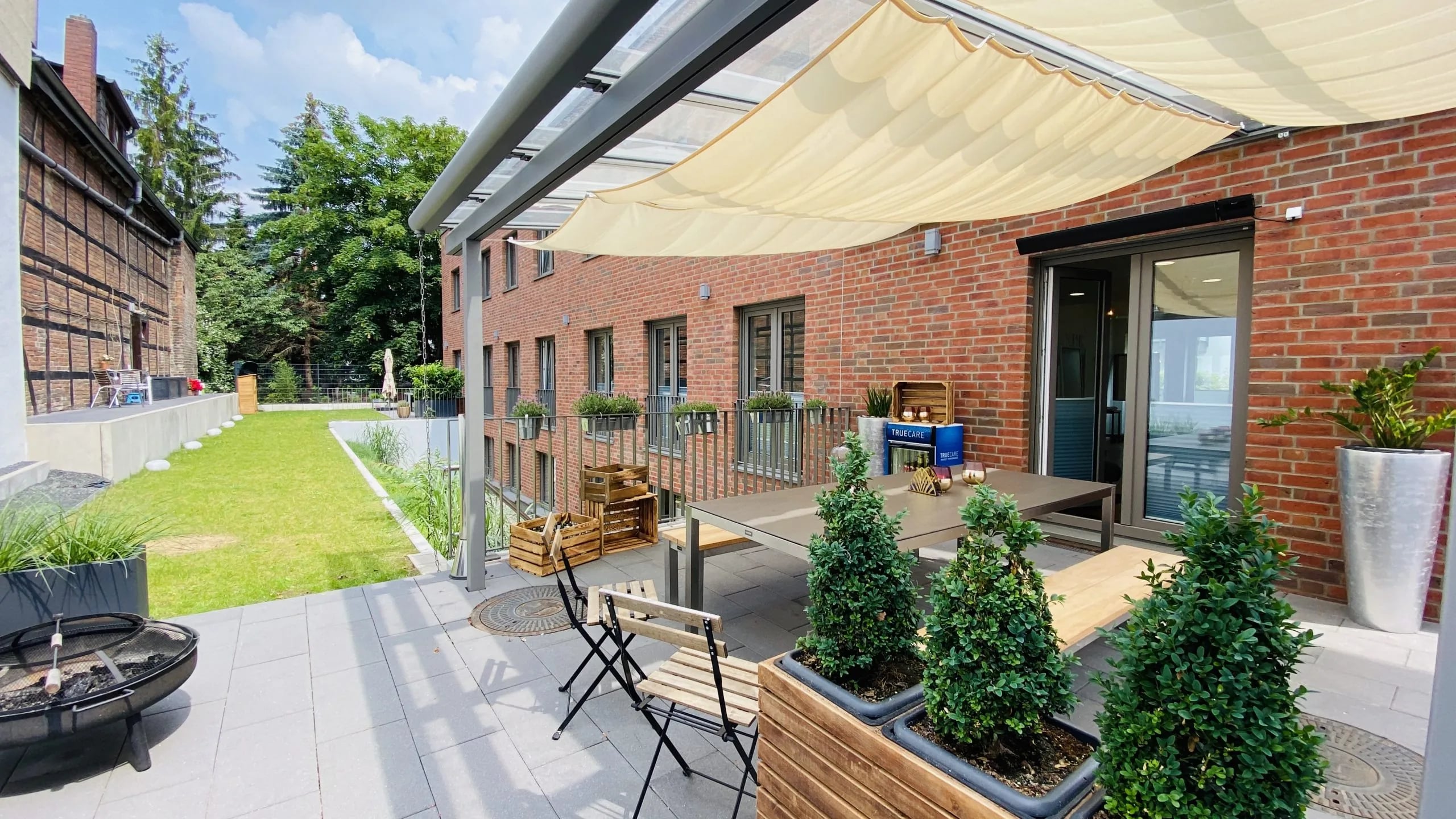 Terrasse mit Sonnensegel und Feuerschale im Innenhof der Kronenstraße 13 in Hannover