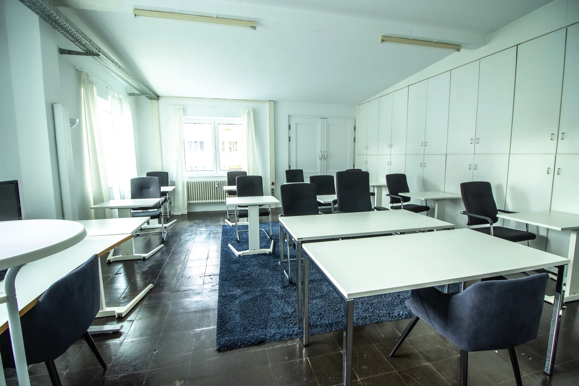 Heller Gruppenraum im Maschinenraum Hannover mit weißen Tischen und Bürostühlen