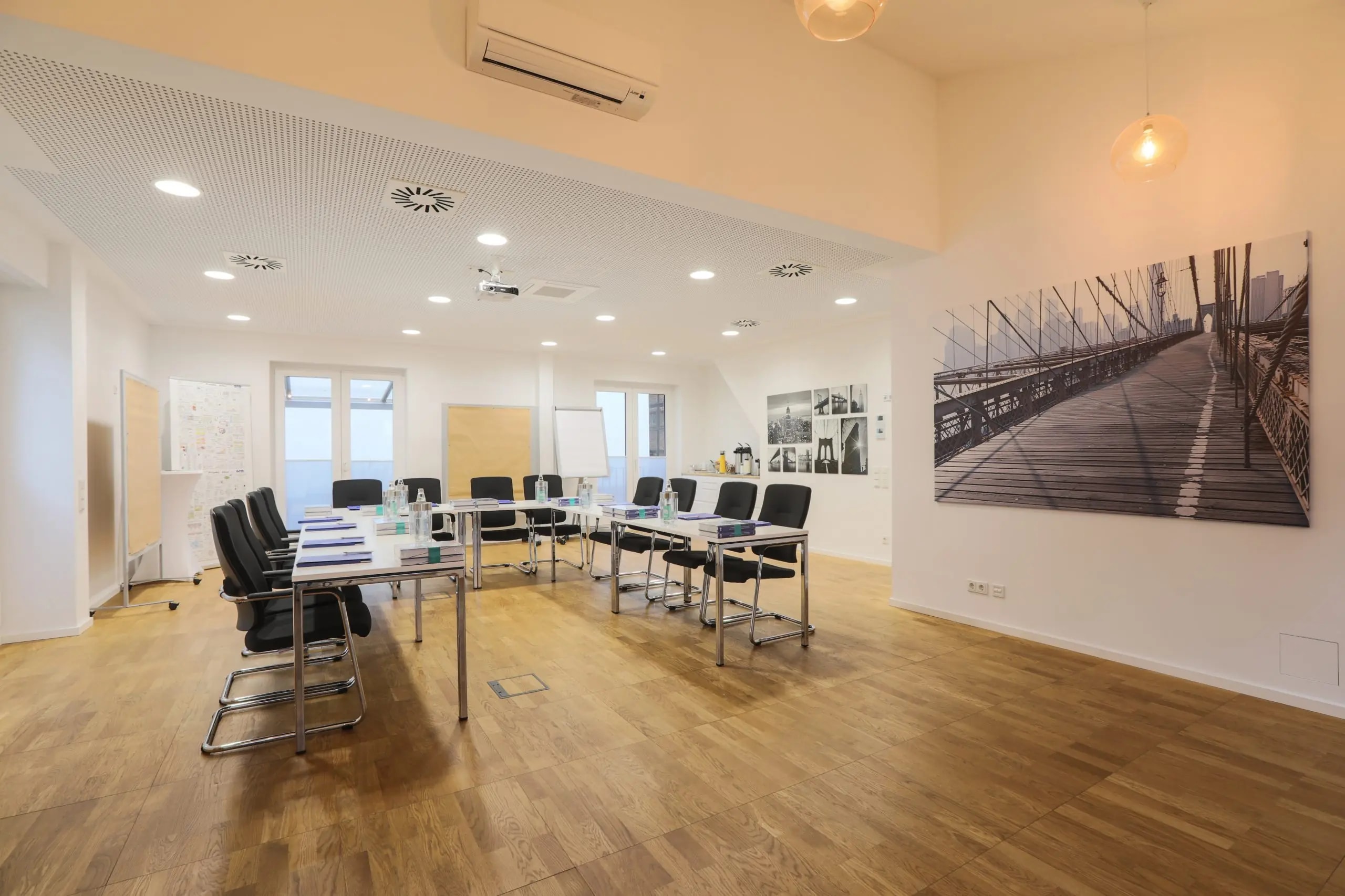 Seminarraum New York in Hannover mit Tischreihen, Bürostühlen und großformatigem Brooklyn-Bridge-Bild